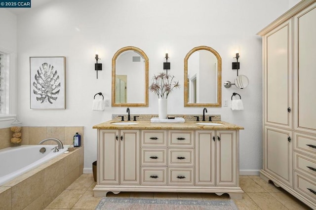 bathroom featuring tile patterned flooring, vanity, and tiled tub