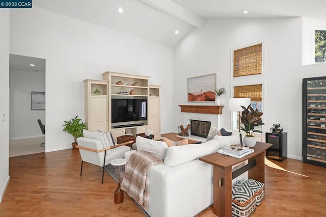 living room featuring wine cooler, wood-type flooring, beam ceiling, and high vaulted ceiling