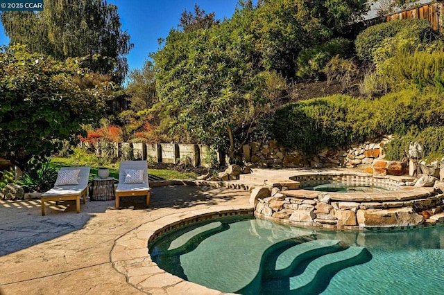 view of pool featuring an in ground hot tub and a patio