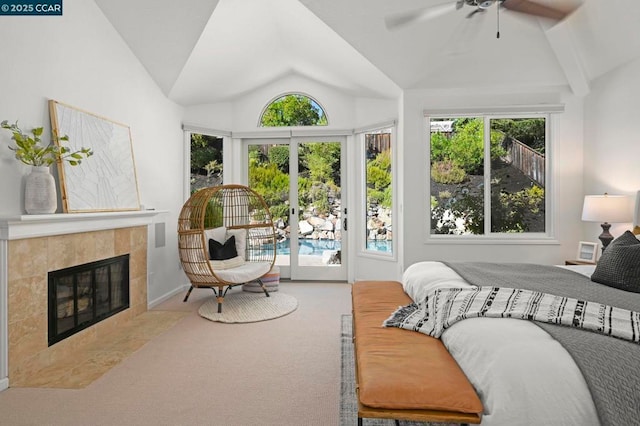 carpeted bedroom with lofted ceiling, ceiling fan, access to exterior, a tiled fireplace, and multiple windows