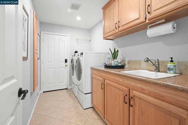 clothes washing area with cabinets, washing machine and dryer, sink, and light tile patterned flooring