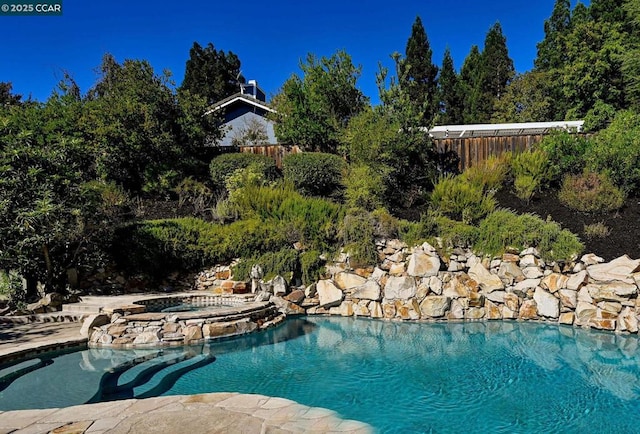 view of pool featuring an in ground hot tub