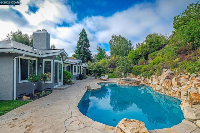 view of swimming pool with an in ground hot tub and a patio