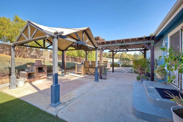 view of patio featuring an outdoor fireplace, a gazebo, and a bar