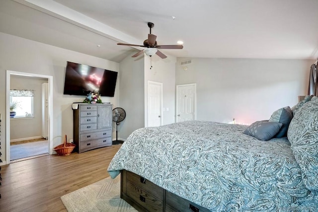 bedroom featuring connected bathroom, vaulted ceiling with beams, light wood-type flooring, a closet, and ceiling fan