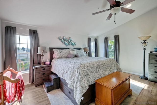 bedroom featuring vaulted ceiling, ceiling fan, light hardwood / wood-style floors, and multiple windows