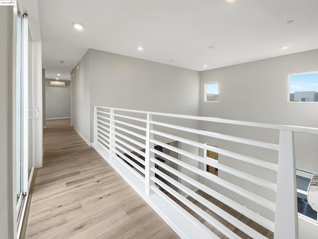 hallway featuring an AC wall unit and light hardwood / wood-style flooring