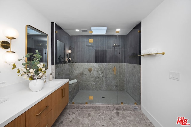 bathroom with a shower with shower door and vanity