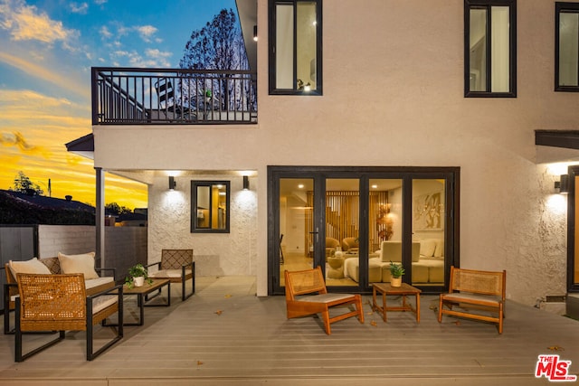 deck at dusk featuring outdoor lounge area