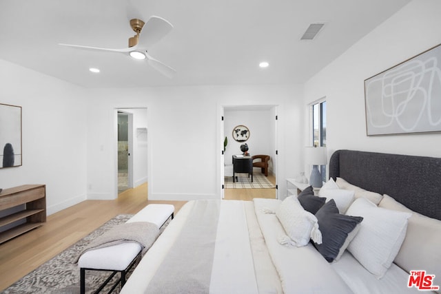 bedroom with ceiling fan, ensuite bathroom, and light hardwood / wood-style floors