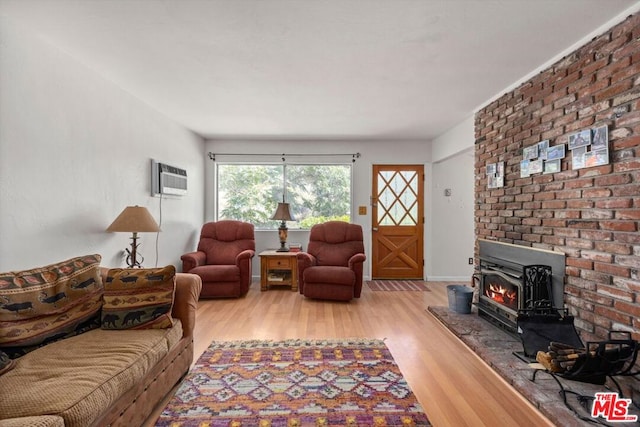 living room featuring light hardwood / wood-style floors and an AC wall unit