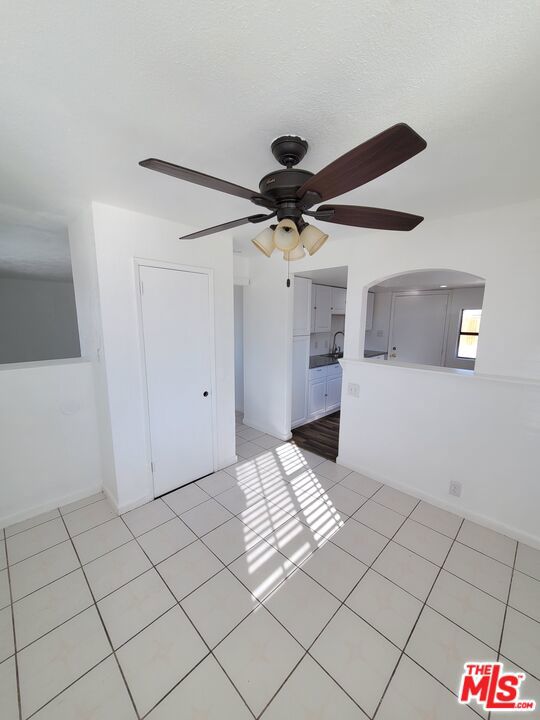 interior space with ceiling fan, light tile patterned floors, and sink