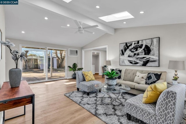 living room with hardwood / wood-style flooring, lofted ceiling with skylight, and ceiling fan