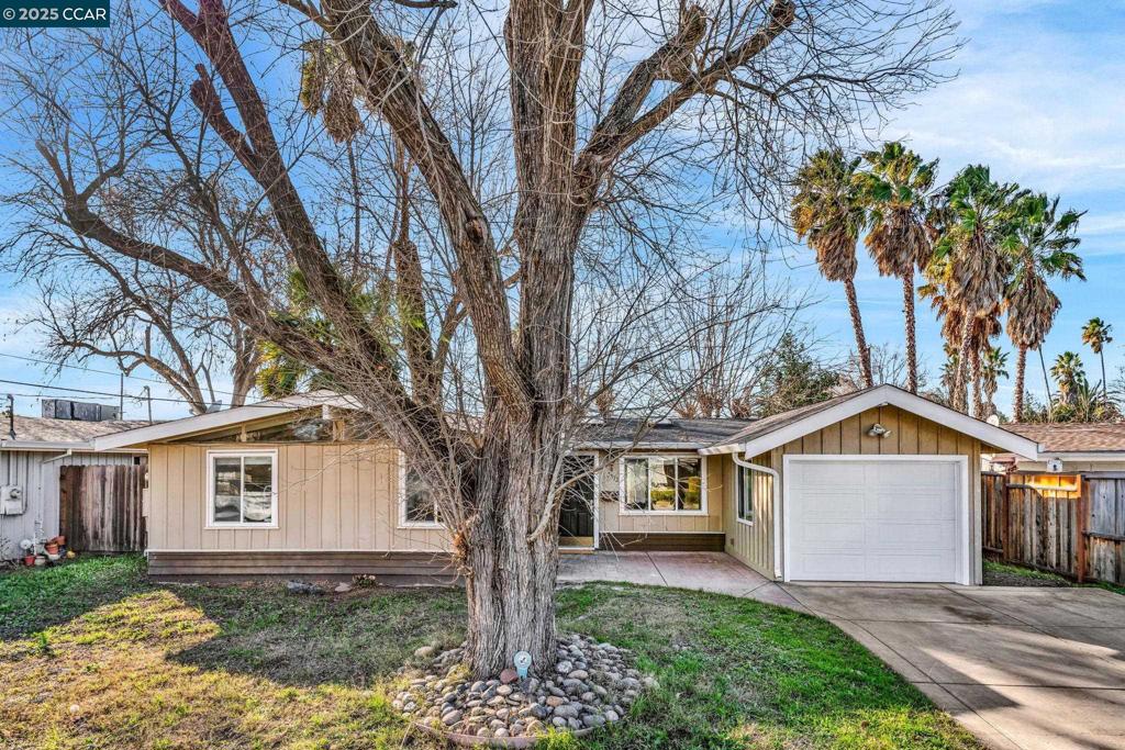 ranch-style house with a garage and a front lawn