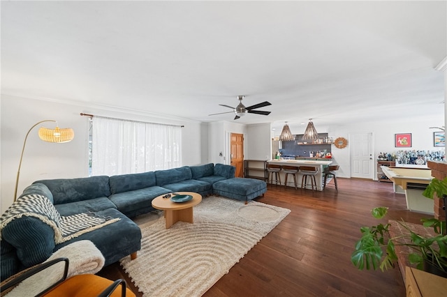 living room featuring ceiling fan, dark hardwood / wood-style flooring, and bar area