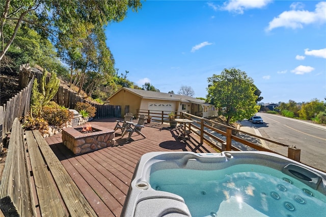 view of swimming pool featuring a wooden deck and an outdoor fire pit