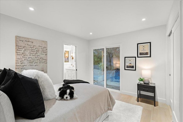 bedroom with ensuite bath, access to outside, and light hardwood / wood-style floors