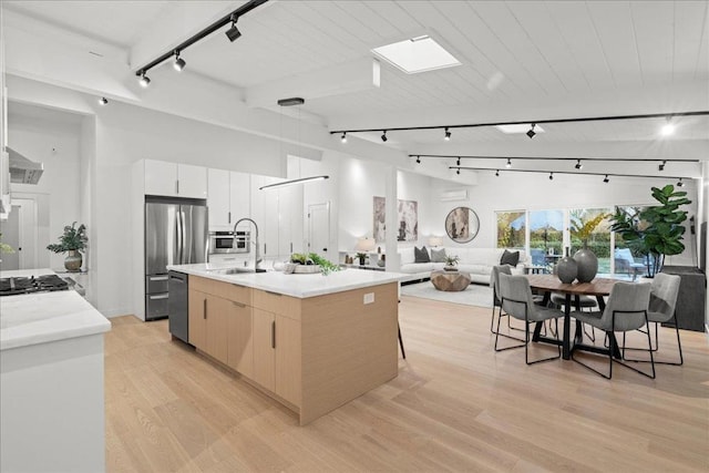 kitchen featuring sink, white cabinets, a center island with sink, wooden ceiling, and light hardwood / wood-style flooring