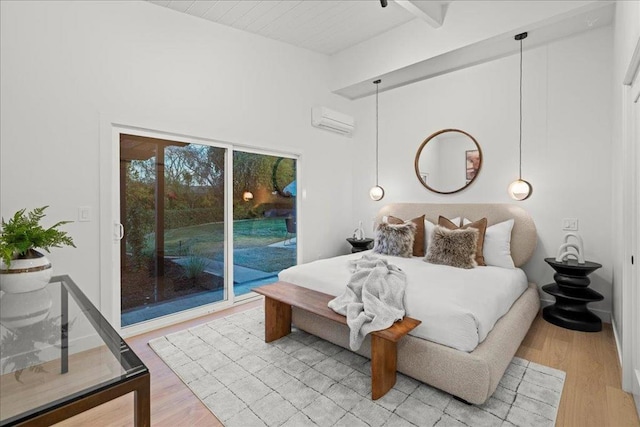 bedroom with wood-type flooring, beam ceiling, access to outside, and a wall mounted AC