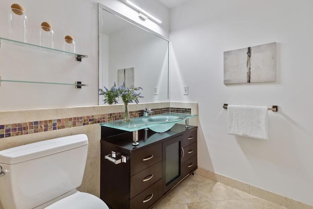 bathroom with toilet, vanity, and tile patterned flooring