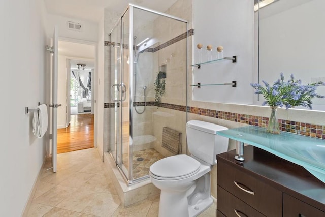 bathroom featuring toilet, tile patterned flooring, and a shower with door