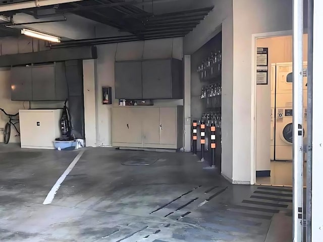 garage with stacked washer and clothes dryer