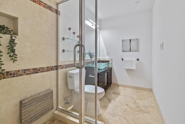 bathroom featuring toilet, tile walls, a shower with shower door, and vanity