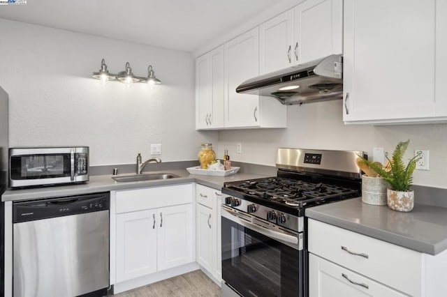 kitchen featuring white cabinets, sink, stainless steel appliances, and light hardwood / wood-style flooring