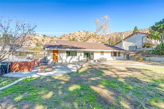 rear view of house featuring a mountain view, a patio area, and exterior kitchen