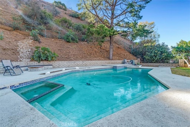 view of swimming pool with a diving board and an in ground hot tub