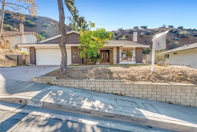 view of front of property with a garage and a mountain view