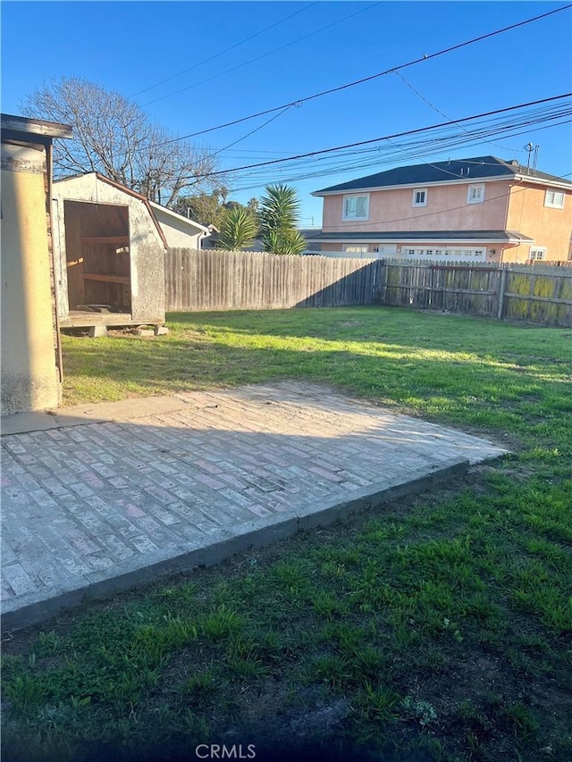 view of yard featuring a storage shed and a patio