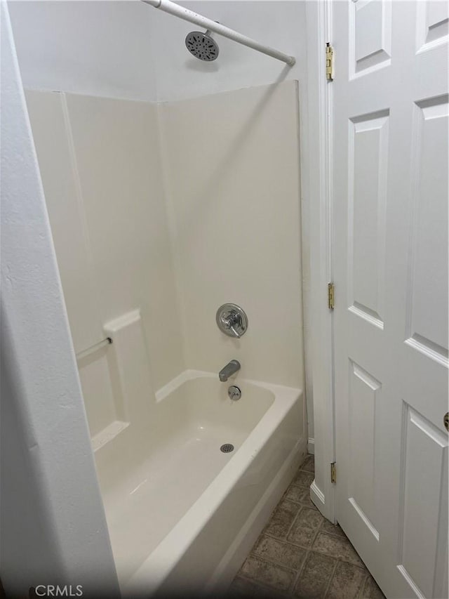 bathroom featuring bathing tub / shower combination and tile patterned flooring