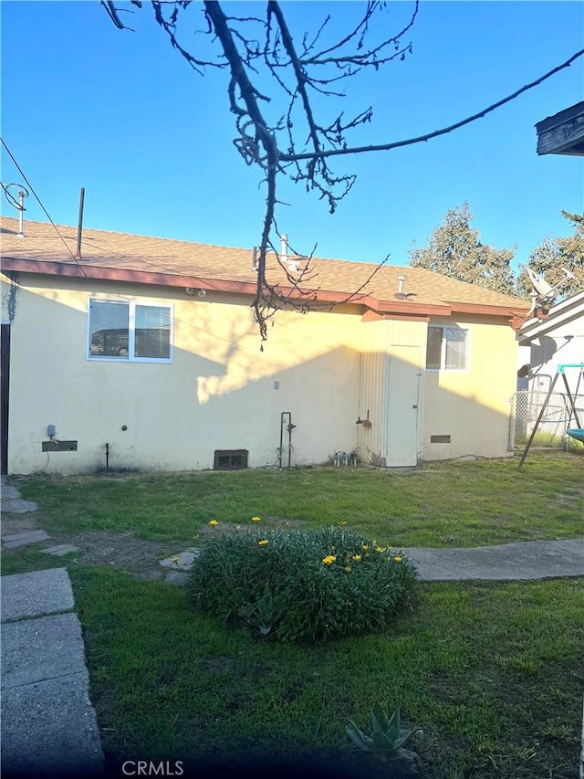 rear view of property featuring a lawn