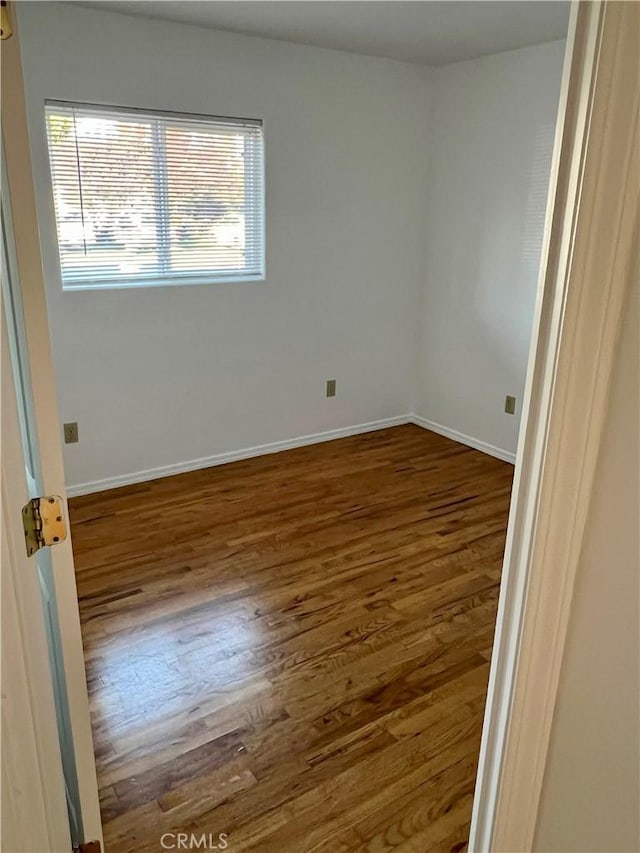 unfurnished room with dark hardwood / wood-style floors