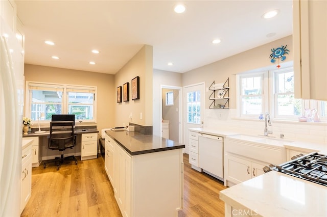 kitchen with white cabinetry, sink, white dishwasher, and light hardwood / wood-style floors