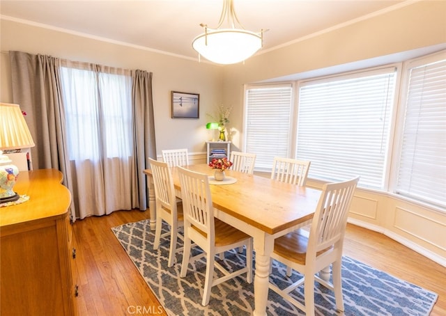 dining area featuring crown molding and light hardwood / wood-style floors