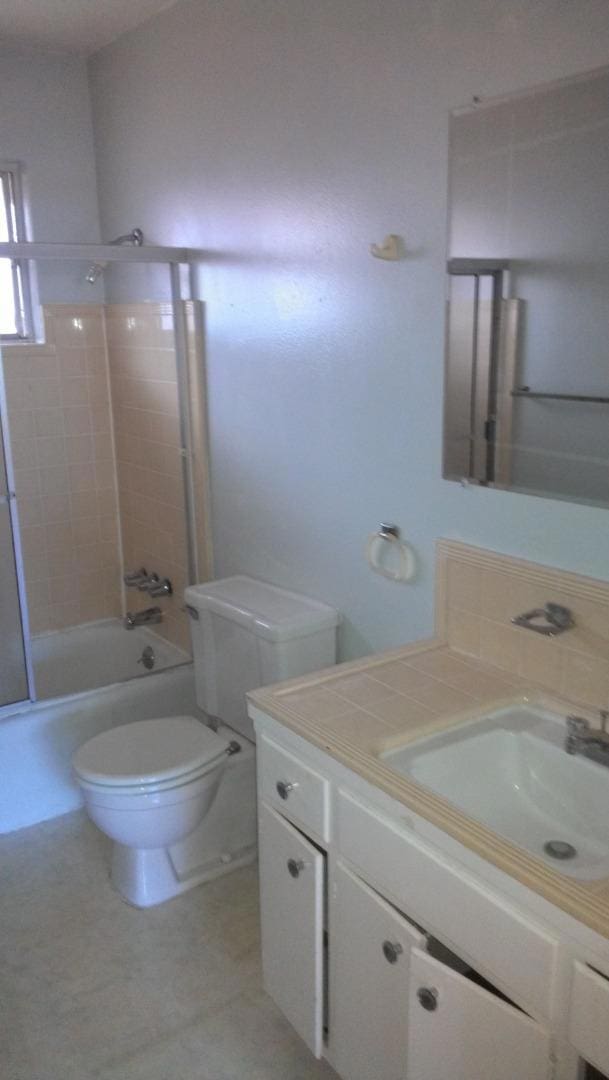 full bathroom featuring toilet, vanity, and tiled shower / bath