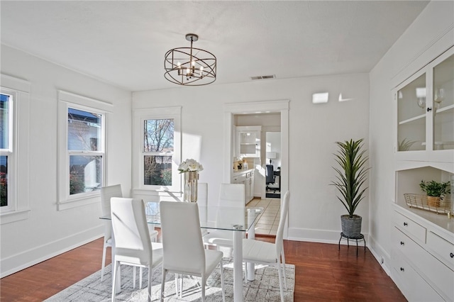 dining area with light wood-type flooring and an inviting chandelier