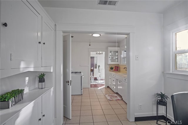 kitchen featuring light tile patterned flooring, white cabinetry, white gas range oven, and sink