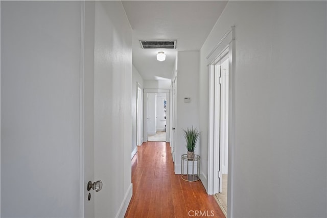 corridor with hardwood / wood-style floors