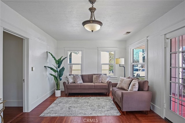 living room featuring a textured ceiling and dark hardwood / wood-style flooring