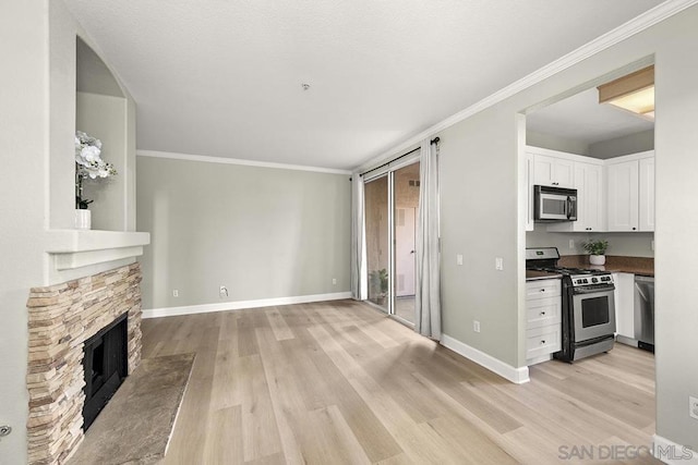 unfurnished living room featuring light wood-type flooring, a fireplace, and crown molding