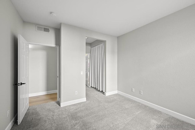 unfurnished bedroom featuring a closet and light carpet