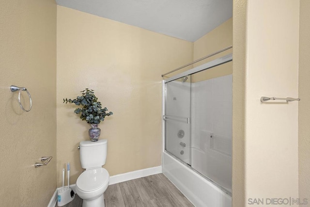 bathroom with toilet, enclosed tub / shower combo, and wood-type flooring