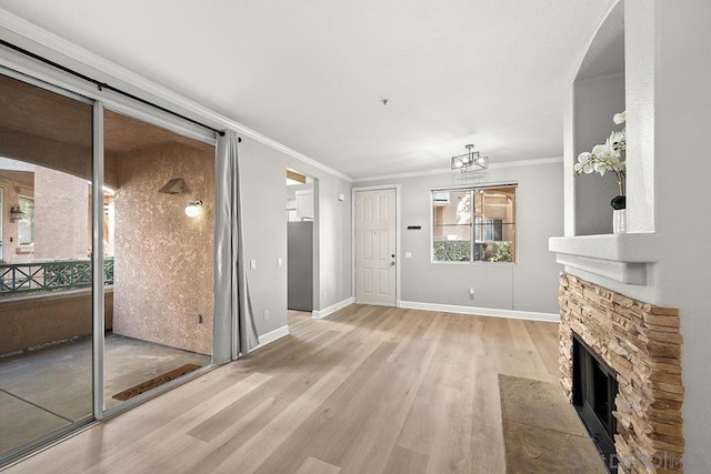 unfurnished living room featuring crown molding, light hardwood / wood-style floors, and a stone fireplace