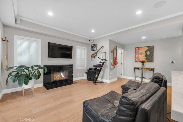 living room with crown molding, a fireplace, and hardwood / wood-style floors