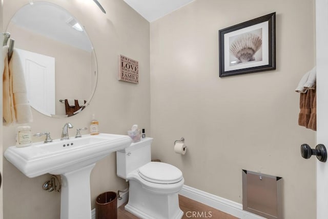 bathroom featuring toilet, hardwood / wood-style floors, and sink