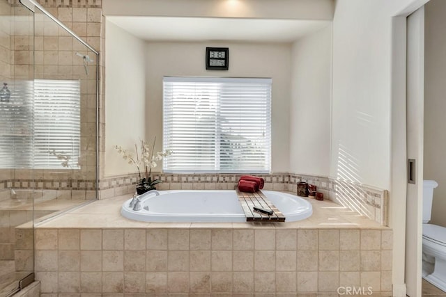 bathroom featuring toilet and shower with separate bathtub