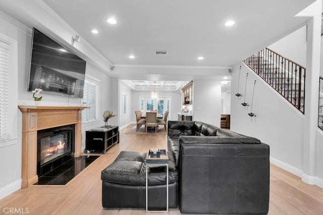 living room featuring crown molding and light hardwood / wood-style floors